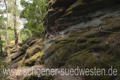 Ein schmaler Pfad entlang einer Felswand.