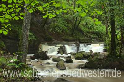 Kleiner Wasserfall im Strümpfelbachtal. Sanft fließt das Wasser um die Steine